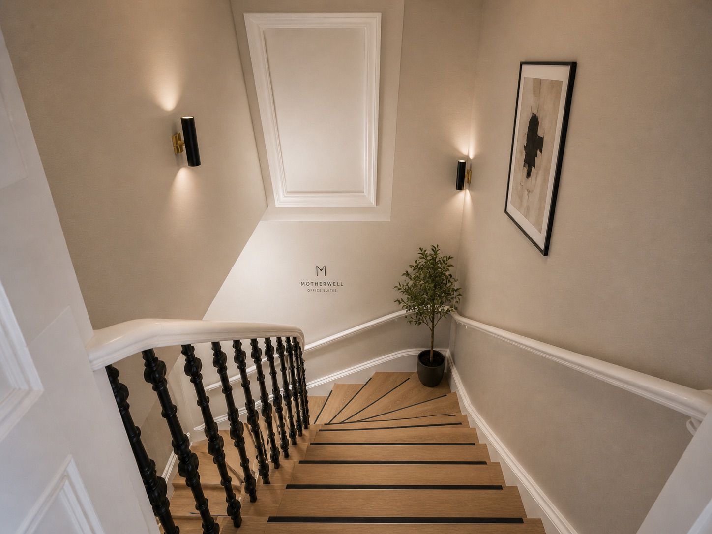 Restored period staircase with Motherwell Office Suites branding