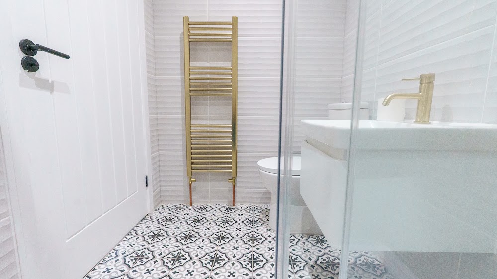 Refurbished bathroom with brass fixtures and patterned tiling